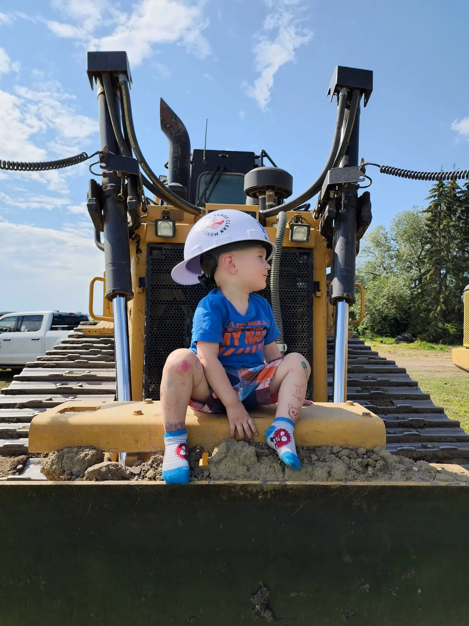 child sitting on dozer with hard hat